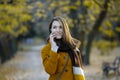 Young woman using mobile phone in autumn park Royalty Free Stock Photo