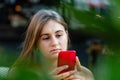 Young woman using mobile phone, communication, looking at digital screen, sitting in street cafe Royalty Free Stock Photo