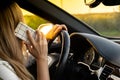 Young woman using mobile phone while driving car on highway road during sunset. Womandriver has accident calling with Royalty Free Stock Photo