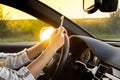 Young woman using mobile phone while driving car on highway road during sunset. Womandriver has accident calling with Royalty Free Stock Photo