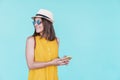 Young woman using mobile phone outdoors over turquoise background. Summer time Royalty Free Stock Photo