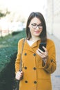 Young woman using mobile phone outdoors texting Royalty Free Stock Photo