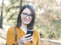 Young woman using mobile phone outdoors texting Royalty Free Stock Photo