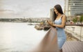 Young woman using a mobile phone while standing on the river promenade Royalty Free Stock Photo