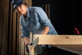 Young woman using modern electric saw in the workshop