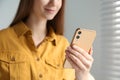 Young woman using modern smartphone indoors Royalty Free Stock Photo