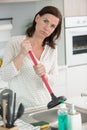 young woman using plunger in blocked kitchen sink Royalty Free Stock Photo