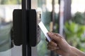 Young woman using RFID tag key, fingerprint and access control  to open the door in a office building Royalty Free Stock Photo