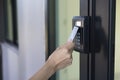 Young woman using RFID tag key, fingerprint and access control to open the door in a office building Royalty Free Stock Photo