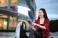 Woman using smart phone while sitting on stairs in the city at night. Royalty Free Stock Photo