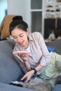 Young woman using smart phone taking photo of her cat on sofa. Royalty Free Stock Photo