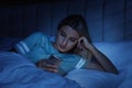 Young woman using smartphone in bed at night. Nomophobia and sleeping disorder problem Royalty Free Stock Photo