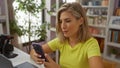 Young woman using smartphone in a bright, interior decor store or home, displaying an attractive, beautiful, and focused Royalty Free Stock Photo