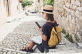 Young woman using smartphone in Corfu old town. Traveler girl looking at mobile phone at italian street. Royalty Free Stock Photo