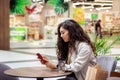 Young woman using smartphone and drinking take away coffee in paper cup. Royalty Free Stock Photo