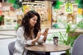 Young woman using smartphone and drinking take away coffee in paper cup. Royalty Free Stock Photo