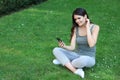 Young woman using smartphone on green grass outdoors Royalty Free Stock Photo