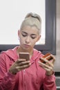 Young woman using smartphone and holding credit card at the kitchen Royalty Free Stock Photo