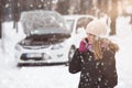 Young woman using smartphone to call road assistance. Winter and Royalty Free Stock Photo