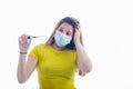 Young woman using a surgical mask with her left hand on her head checking a digital thermometer Royalty Free Stock Photo