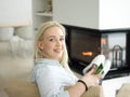 Young woman using tablet computer in front of fireplace Royalty Free Stock Photo