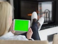 Young woman using tablet computer in front of fireplace Royalty Free Stock Photo