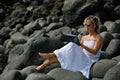 Young woman using tablet on rocky beach in summer Royalty Free Stock Photo