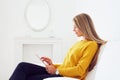 Young woman using tablet sitting on sofa Royalty Free Stock Photo