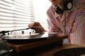 Young woman using turntable at home