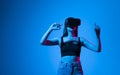 Young woman using the virtual reality headset and interact with a virtual world in a metaverse. Female model wearing VR