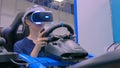 Young woman using virtual reality headset and playing in car drive simulator Royalty Free Stock Photo