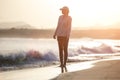 Young woman walking along ocean beach with waves Royalty Free Stock Photo