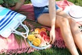 Young woman with various delicious fruits on summer picnic in park