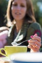 Young woman with varnished nails spooning froth on a coffee as