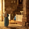 woman with a veil standing in front of the small shrine