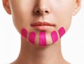 Woman with kinesio tapes on chin, beauty procedure.