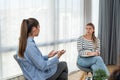 Young woman victim of domestic violence or robbery or mobbing at work talks to an expert psychotherapist for therapy in a comforta Royalty Free Stock Photo