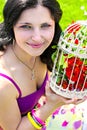 Young woman with vintage birdcage filled with red spring blossom