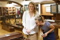 Woman visitor with daughter with guide book pointing exhibition in museum