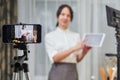 Vlogger recording video for food channel. Female vlogging with her mobile phone mounted on a tripod and a light stand