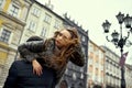 Young woman with voluminous hair blowing in the wind looks away while lying on man carries a woman on his shoulder. Royalty Free Stock Photo