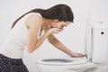 Young woman vomiting into toilet bowl Royalty Free Stock Photo