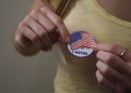 Woman applying an I voted sticker on election day