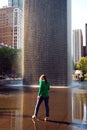 A young woman wades in the waters of the Crown Fountain