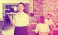 Young woman waiter bringing order for guests Royalty Free Stock Photo