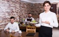 Young woman waiter bringing order for visitors Royalty Free Stock Photo