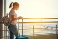 young woman waiting for flying at airport at window with suitcase . Royalty Free Stock Photo