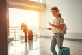 young woman waiting for flying at airport at window with suitcase Royalty Free Stock Photo