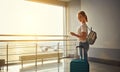 young woman waiting for flying at airport at window with suitcase . Royalty Free Stock Photo