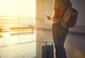 young woman waiting for flying at airport at window with suitcase . Royalty Free Stock Photo